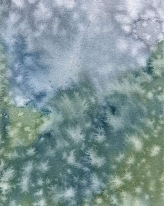 watercolor painting in green and blue and gray with white splotches of every shape where raindrops landed and dispersed the color. gives a vague impression of a green ridgeline in front of a blue-gray cloudy sky