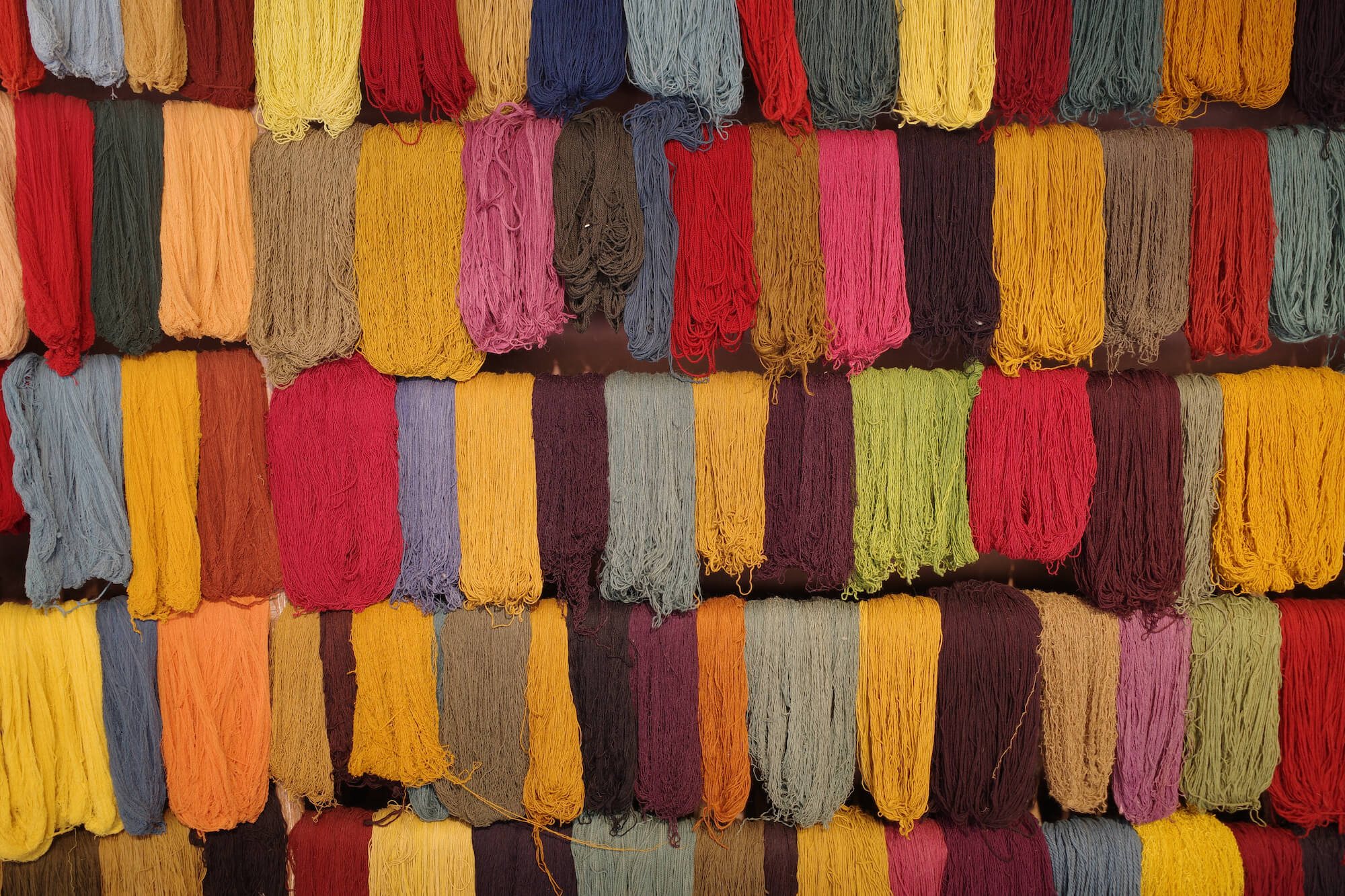 racks of dyed wool yarns in many vibrant colors
