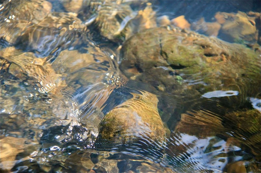 Photo of stones under the current of a river.